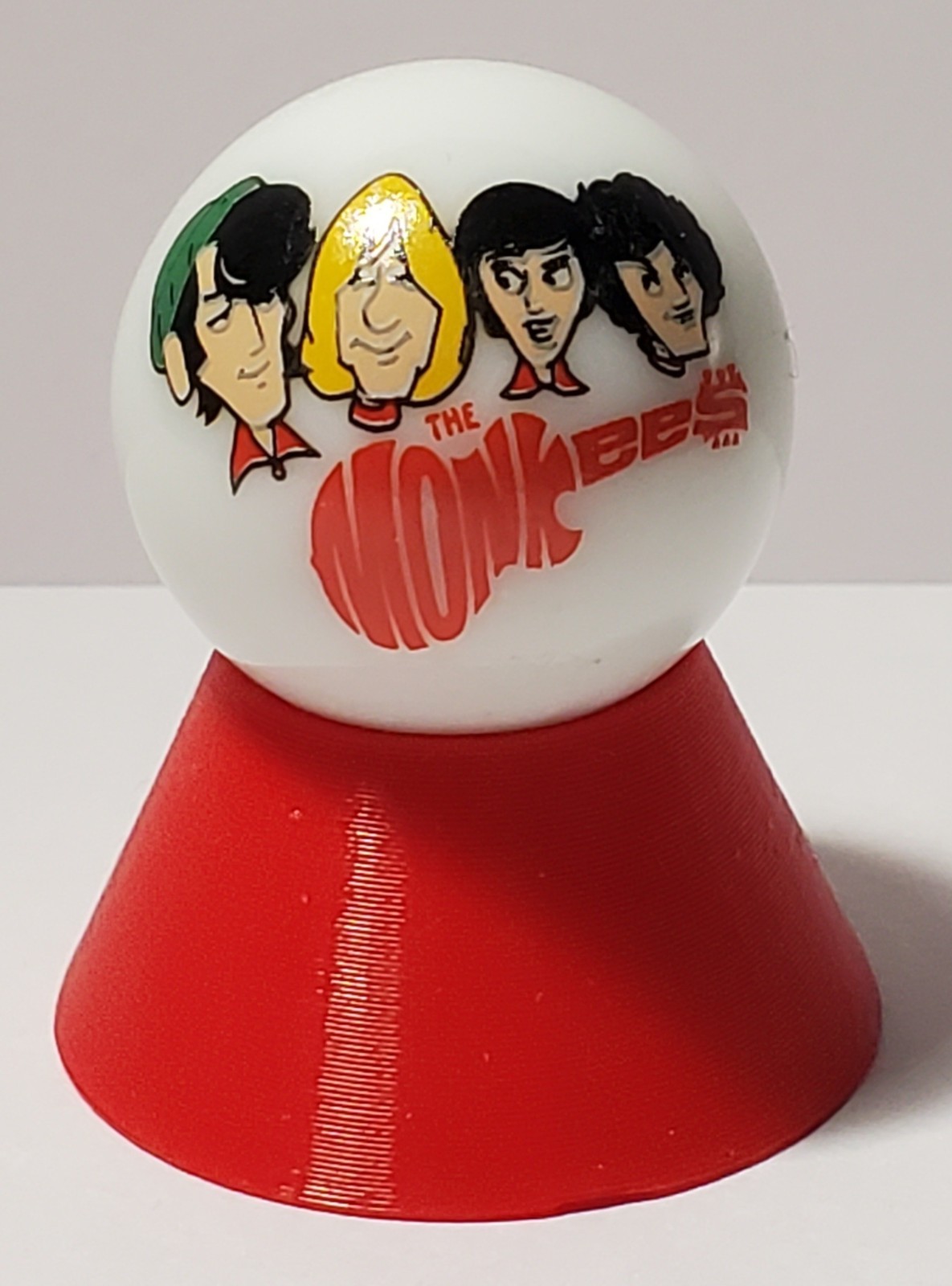 The Monkees Glass 1″ Logo Marble w/ Cone Stand