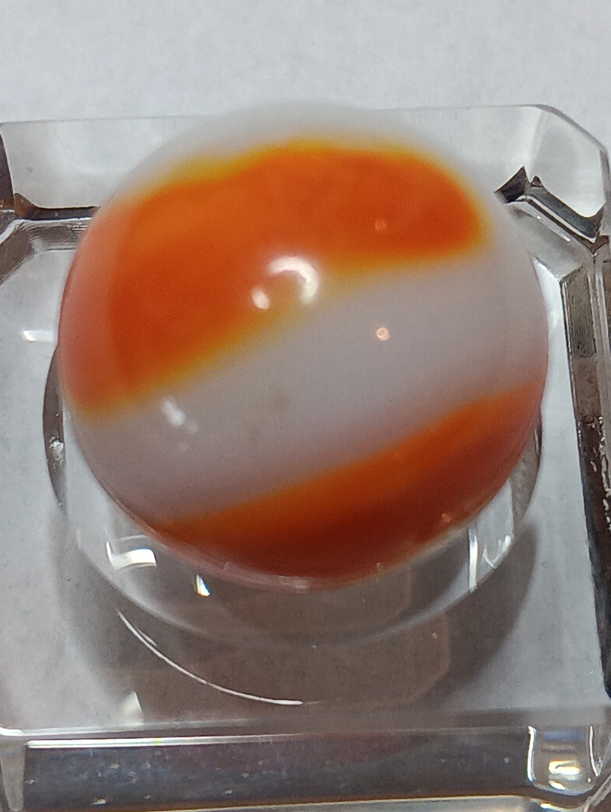 Akro Prize Name Corkscrew Marble. Mint 5/8 Inch, White Base With Orange Swirl