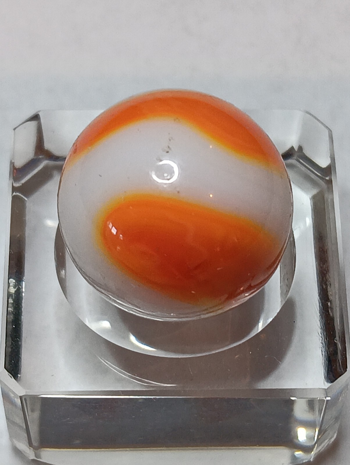 Akro Prize Name Corkscrew Marble. Mint 5/8 Inch, White Base With Orange Swirl