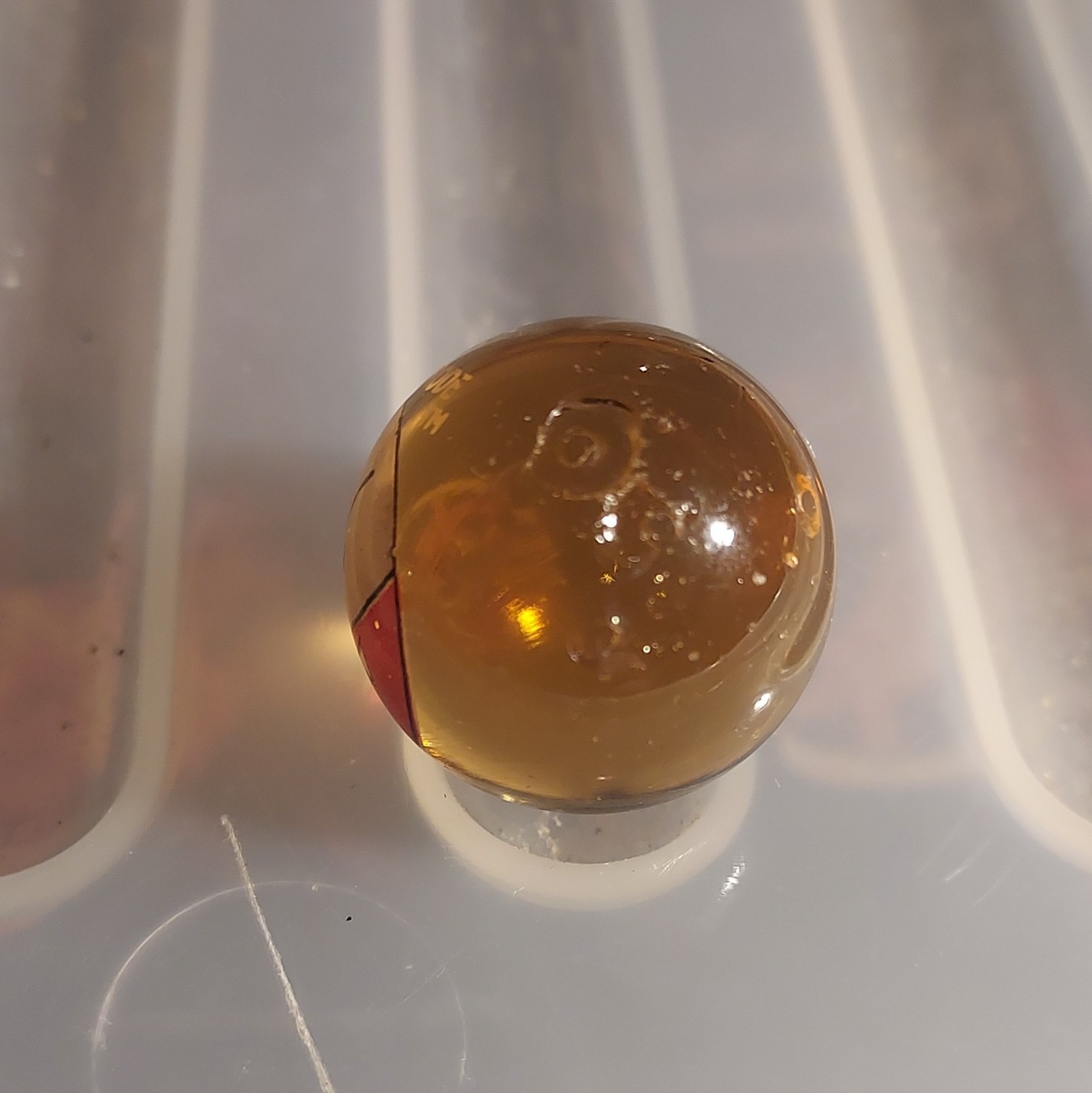 #101 Electrode Logo Printed Glass Toy Marble – Machine Made, Amber/Clear