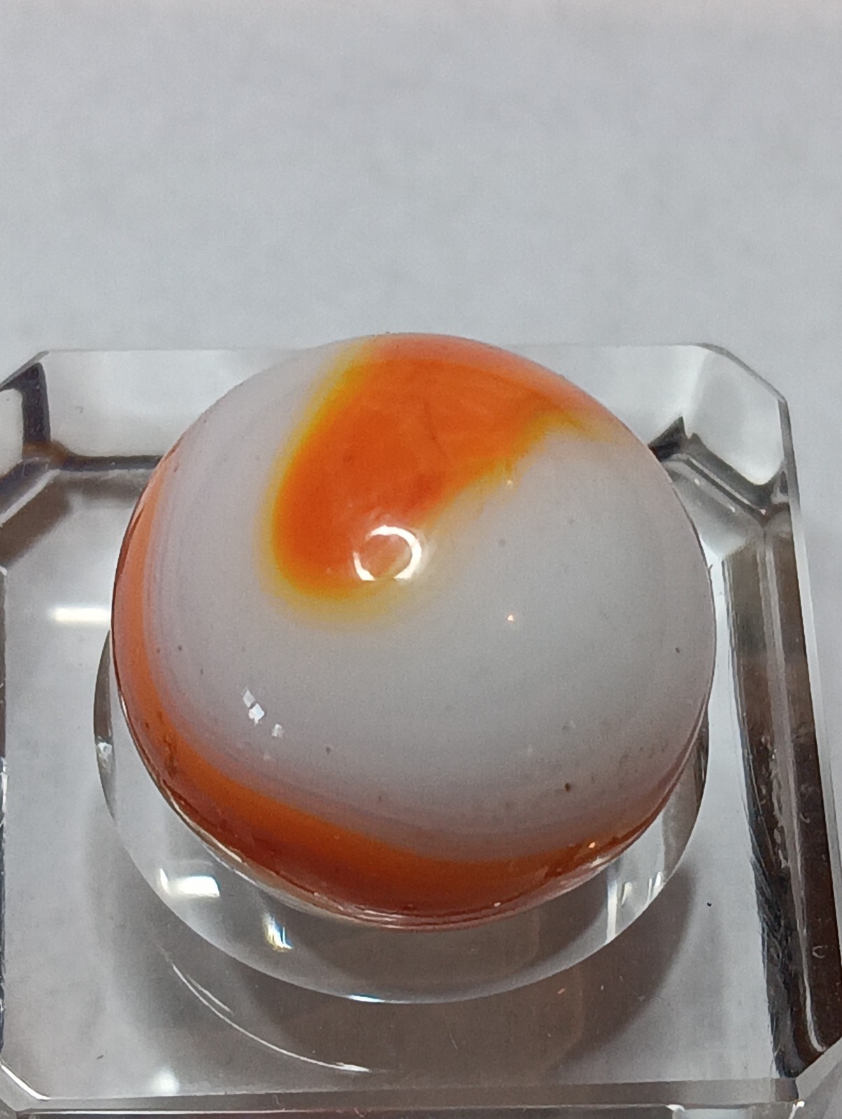 Akro Prize Name Corkscrew Marble. Mint 5/8 Inch, White Base With Orange Swirl
