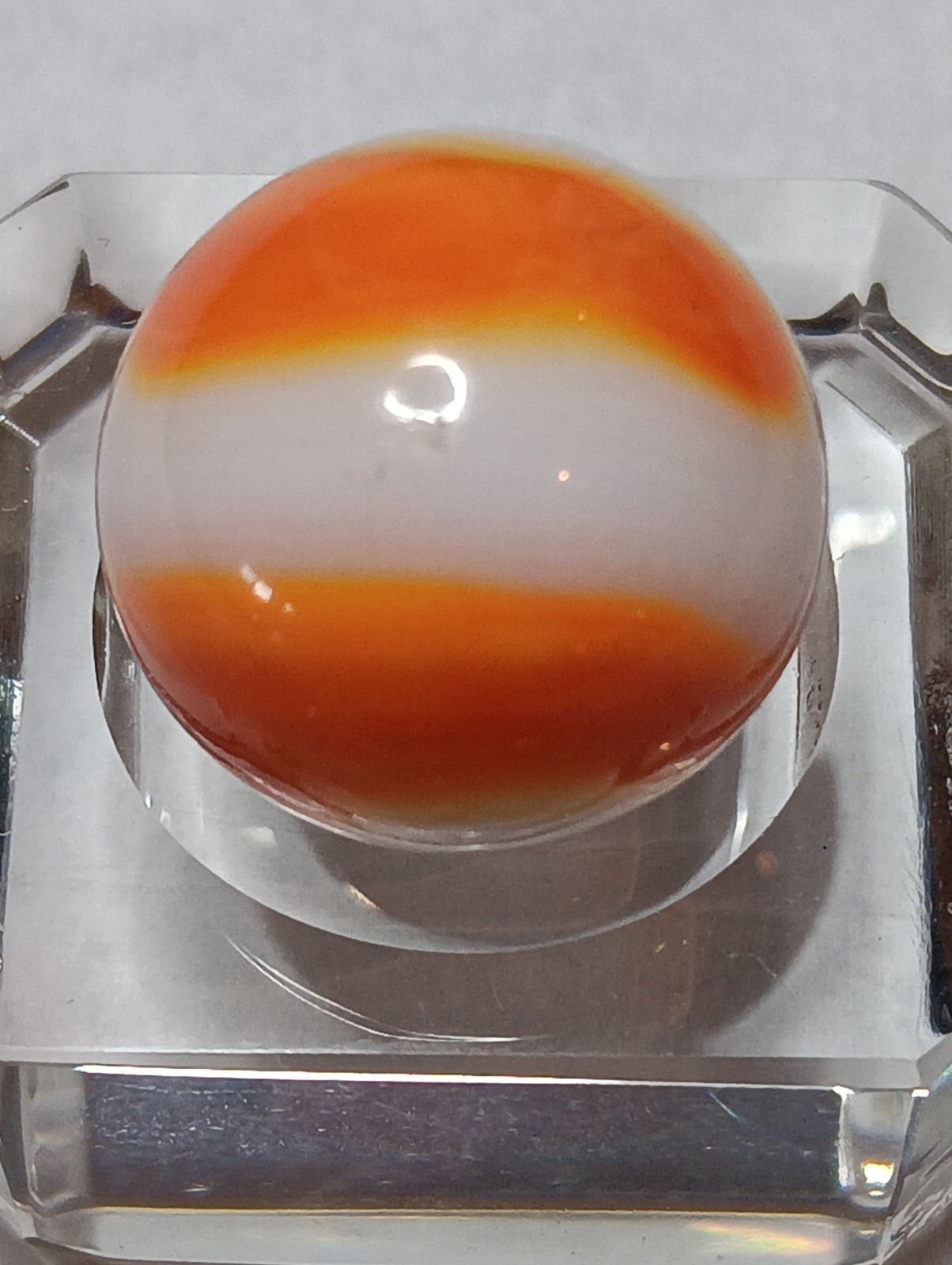 Akro Prize Name Corkscrew Marble. Mint 5/8 Inch, White Base With Orange Swirl