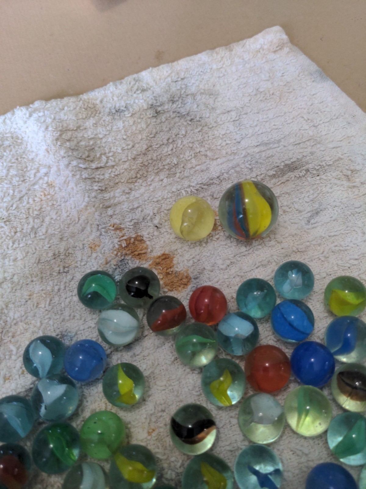 aprox. 50 cat eye marbles with 2 shooters in vintage glass bottle