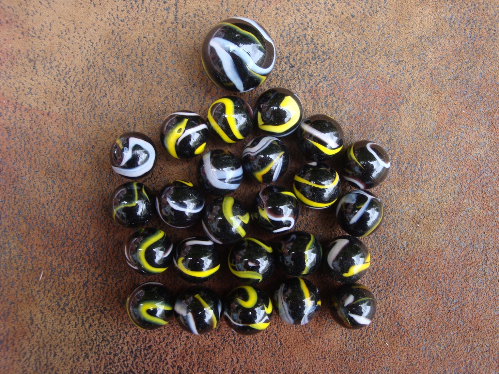 Lot of (25) “Raven” Glass Mega Marbles Black w/ Yellow and White Swirls