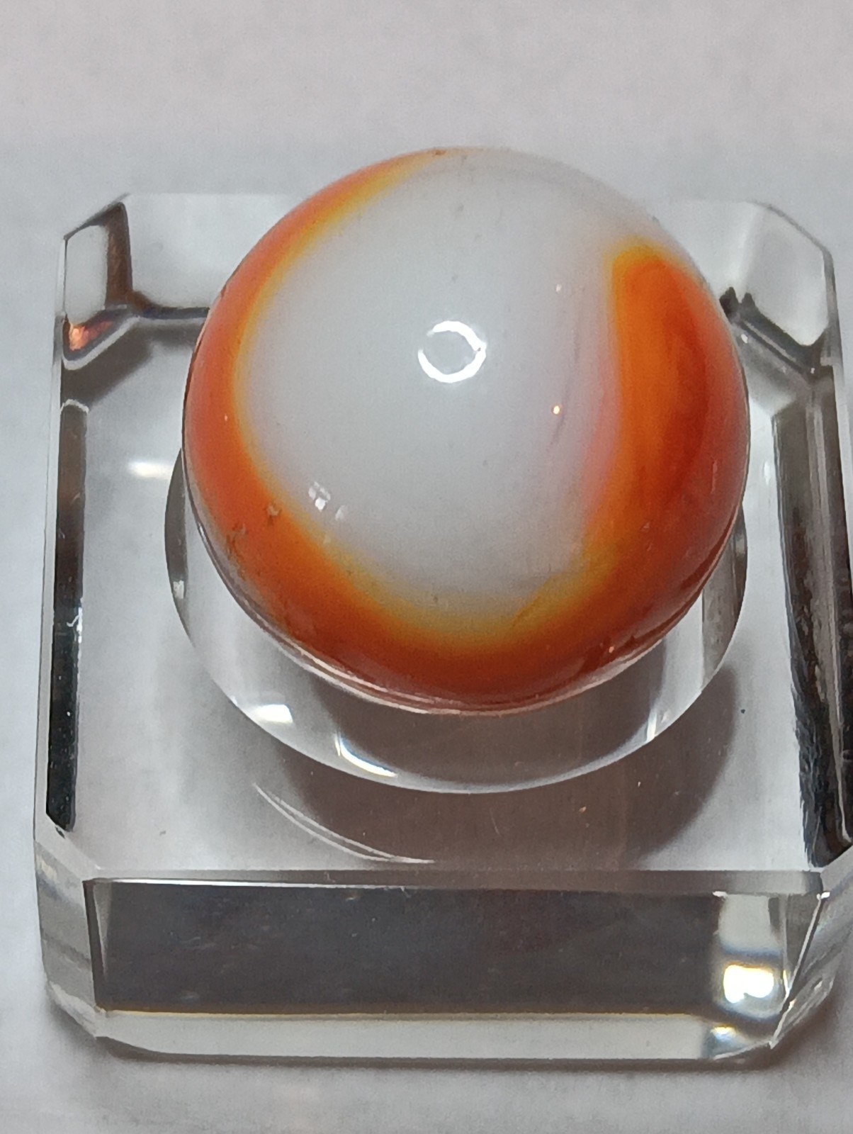 Akro Prize Name Corkscrew Marble. Mint 5/8 Inch, White Base With Orange Swirl