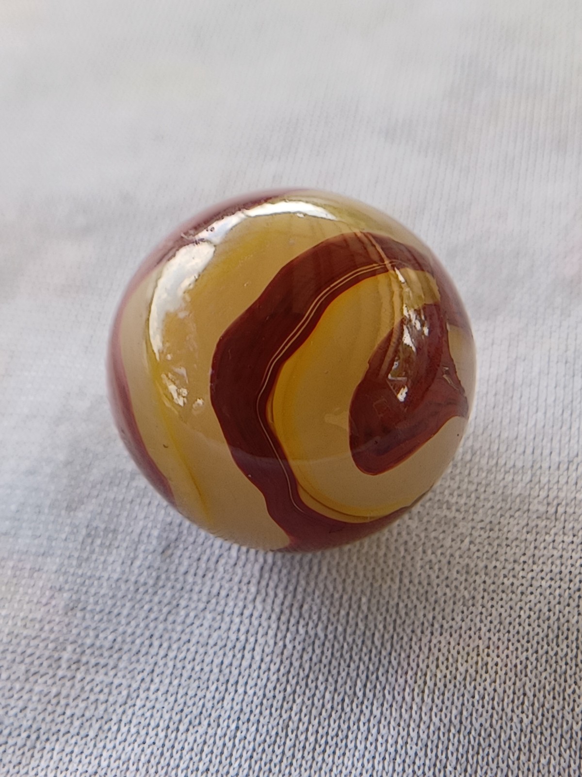 “Golden Onyx Oxblood” .70 Shiney wet dead mint. Very old and rare marble. 1920s