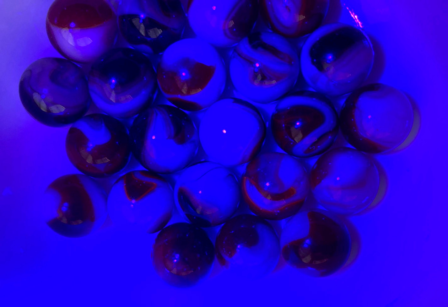 Lot of 24 UV Reactive Red and White Machine Made Marbles Cadmium