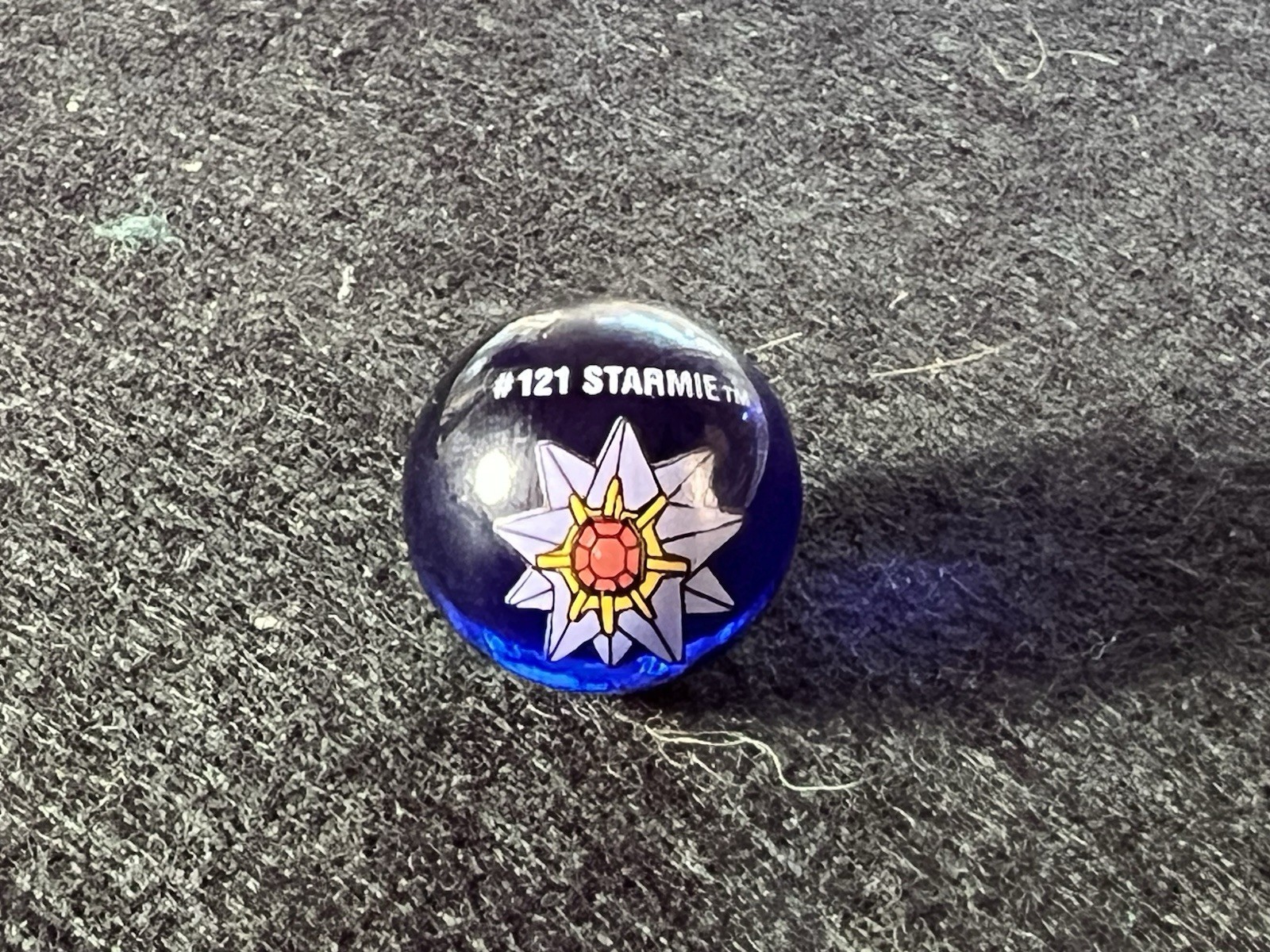 collectible Pokémon marble featuring Starmie, identified by the number #121