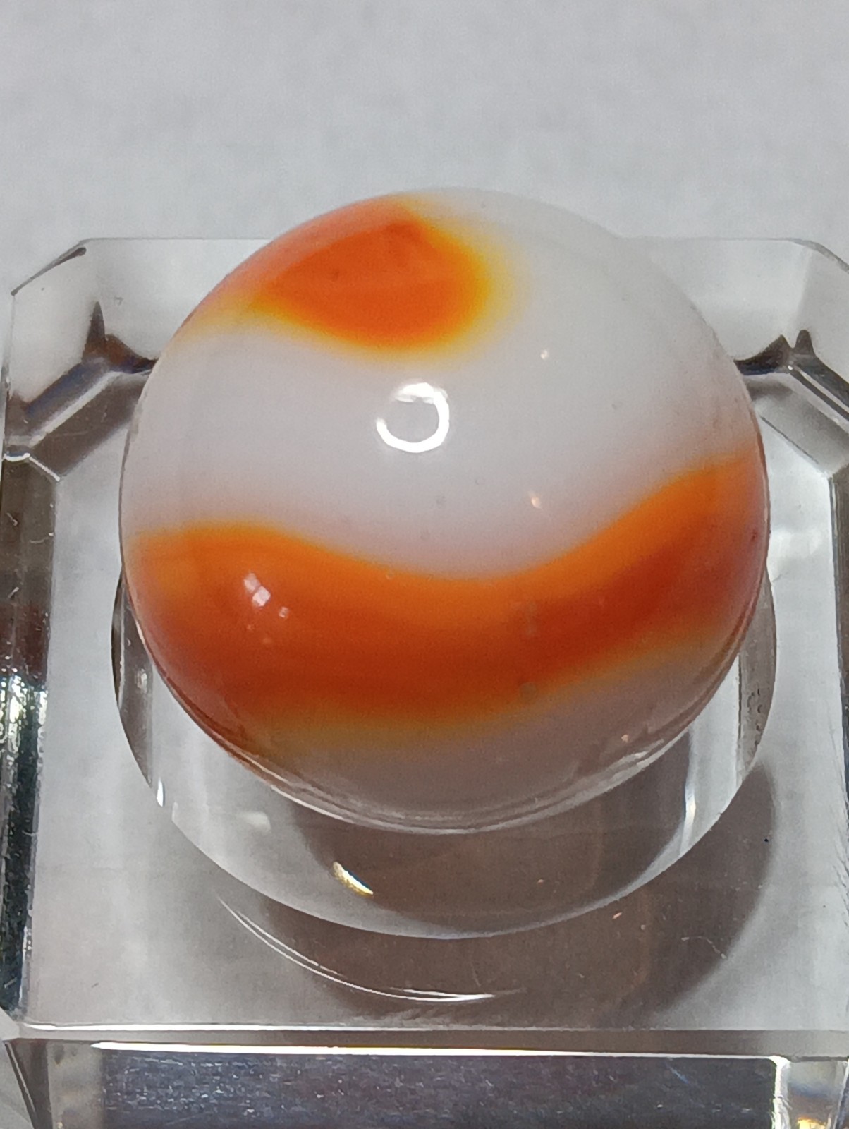 Akro Prize Name Corkscrew Marble. Mint 5/8 Inch, White Base With Orange Swirl