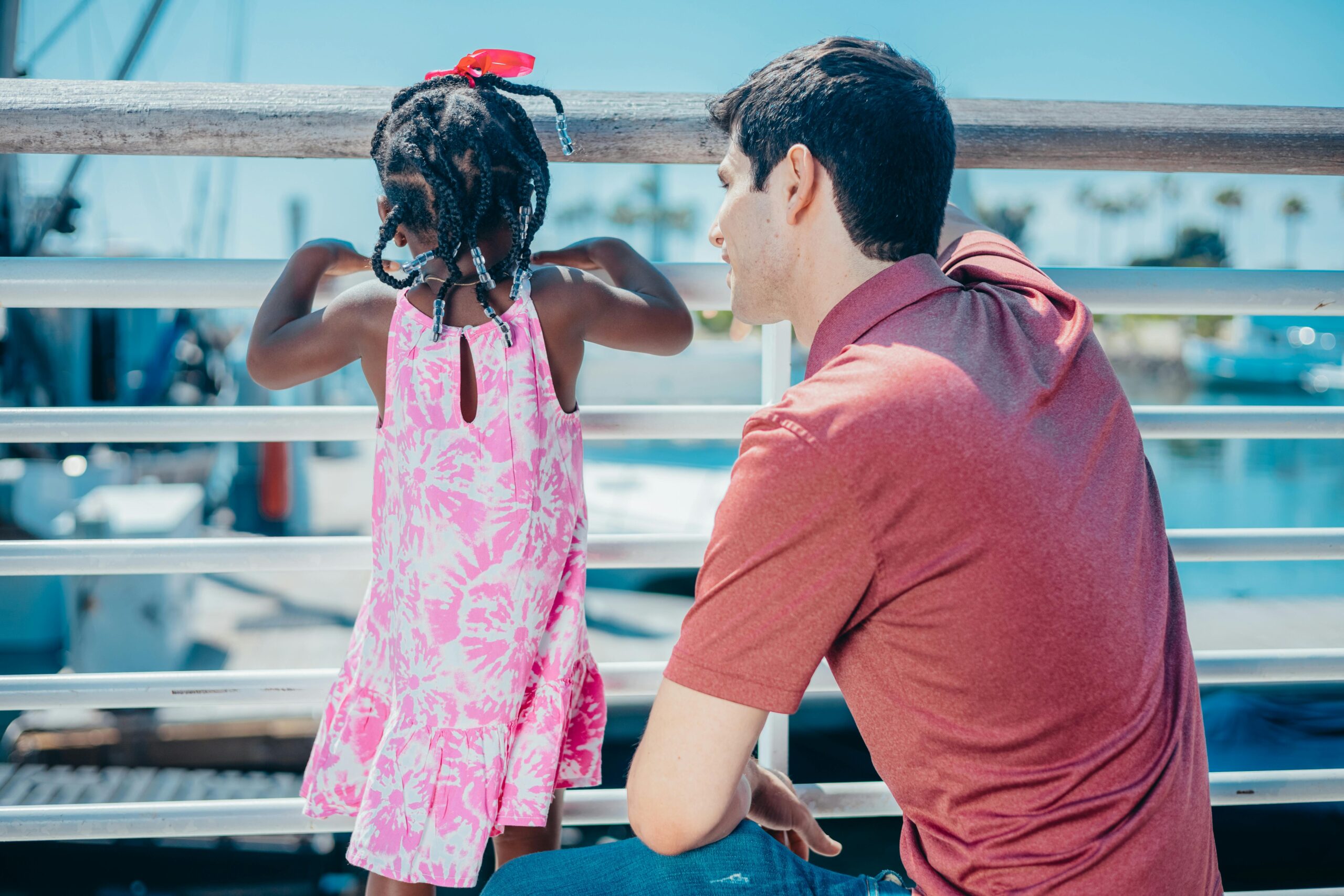 Man and young girl enjoying quality time together on a sunny day by the water.
