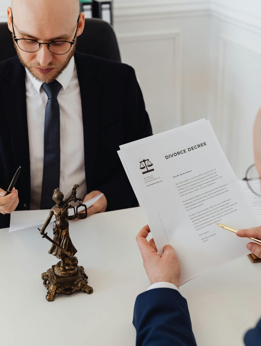 Two lawyers discussing divorce decree documents in a professional office setting.
